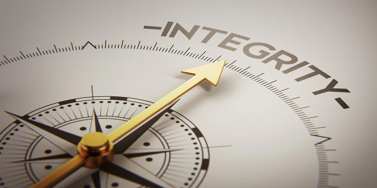 A close-up of a gold compass needle pointing toward the word INTEGRITY in bold letters, symbolizing guidance by strong moral principles—much like roofing integrity guides quality workmanship.