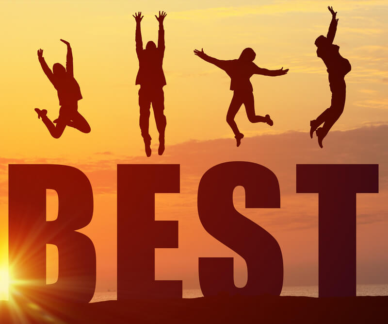 Four people jump joyfully on top of large letters spelling BEST with a vibrant orange sunset sky in the background, celebrating the achievement of being named best roofer in Ottawa.